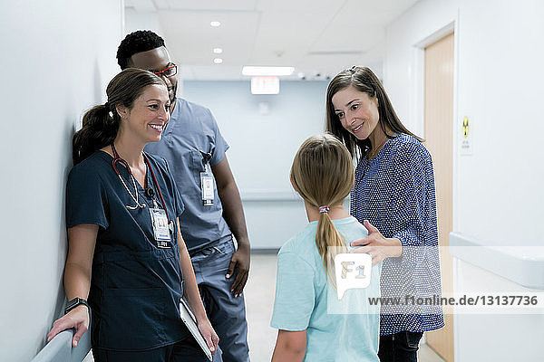 Ärzte sehen überraschte Mutter im Gespräch mit Tochter im Krankenhauskorridor