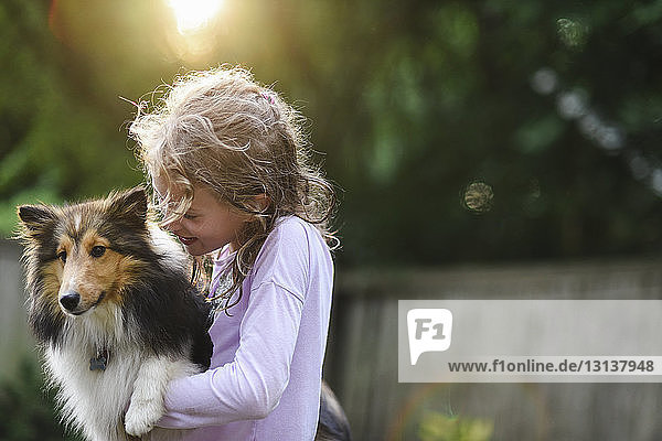 Mädchen spielt mit Hund im Park