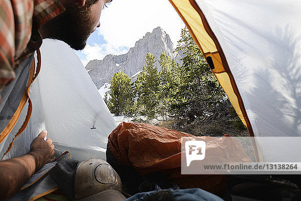 Hiker looking at view through tent at Grand Teton National Park