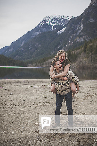 Boyfriend piggybacking girlfriend against mountains at Silver Lake Provincial Park