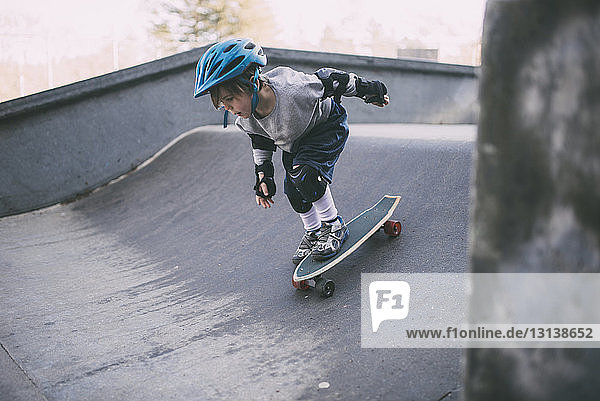 Unbeschwertes Skateboarden eines Jungen auf der Sportrampe im Skateboard-Park