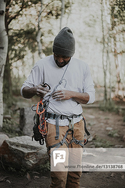 Man attaching carabiners on rope