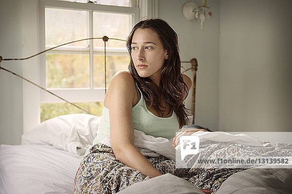 Young woman waking up on bed