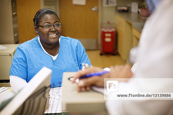 Glückliche Krankenschwester im Gespräch mit dem Arzt im Krankenhaus