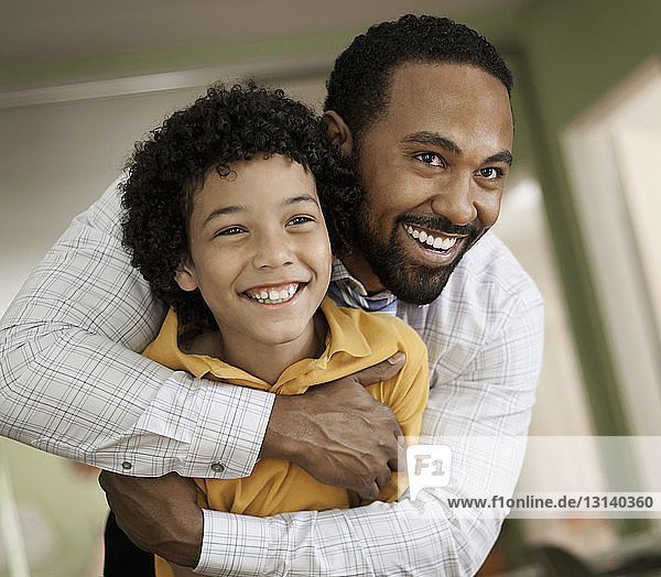Nahaufnahme eines glücklichen Vaters  der seinen Sohn zu Hause umarmt