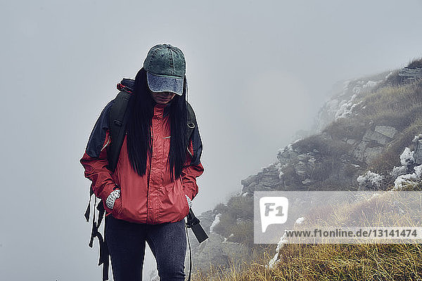 Female hiker standing on Balkan Mountains during foggy weather