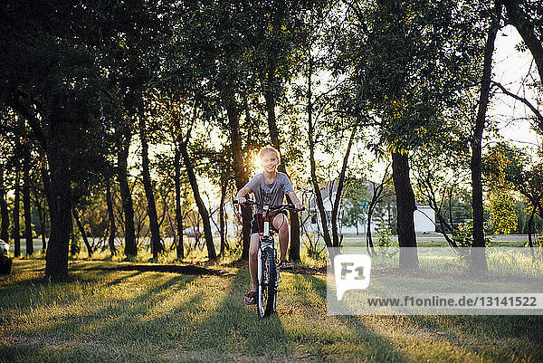 Portrait of girl riding bicycle on grassy field at park