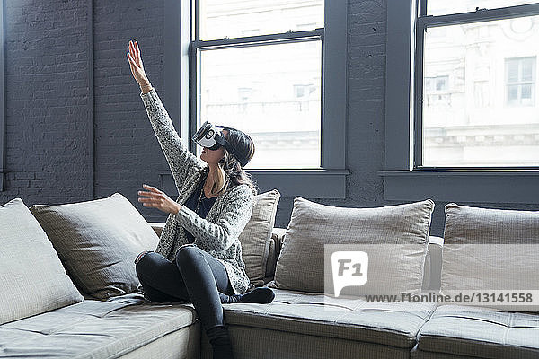 Geschäftsfrau trägt im Büro Gesten eines Virtual-Reality-Simulators