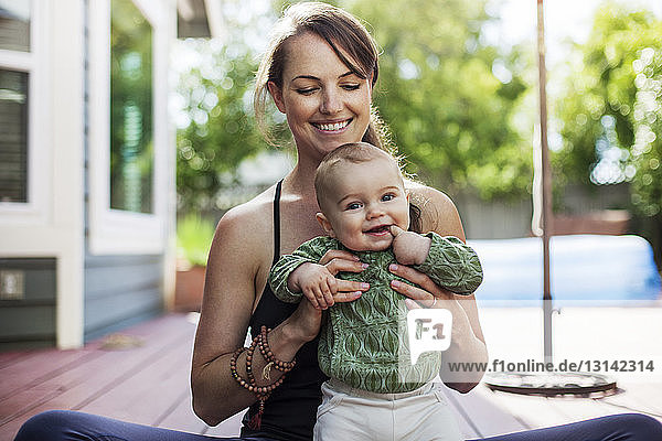 Portrait of cute baby with mother in backyard