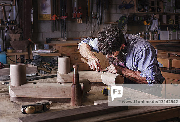 Carpenter making wooden furniture at workshop