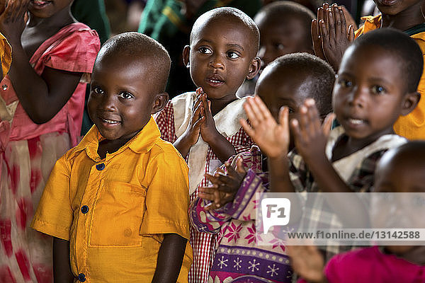 Kinder klatschen im Klassenzimmer in die Hände