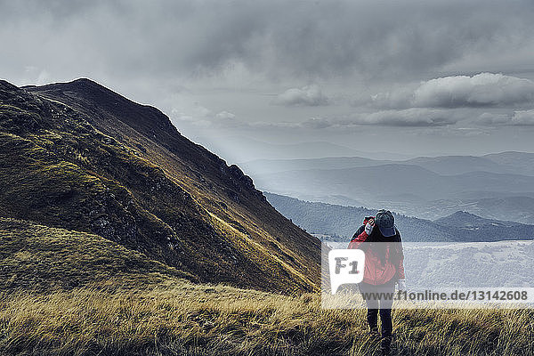 Female hiker standing on Balkan Mountains against cloudy sky