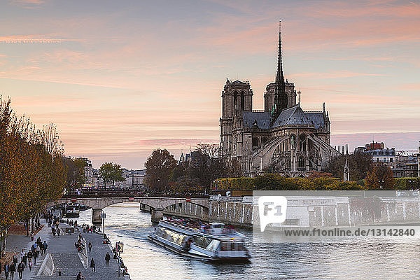 Boot auf der Seine von Notre Dame de Paris gegen den Himmel bei Sonnenuntergang
