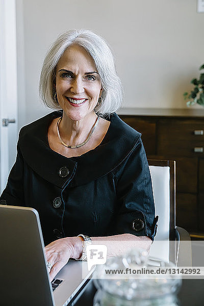 Portrait einer Geschäftsfrau mit Laptop im Büro