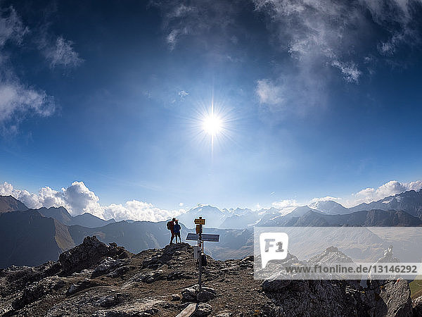Border region Italy Switzerland father and son on peak of Piz Umbrail
