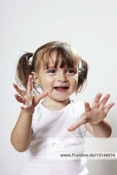 Porträt eines jungen Mädchens mit Zöpfen  mit erhobenen Händen