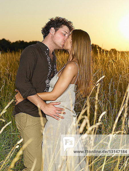 Paar küsst sich  auf einem Feld