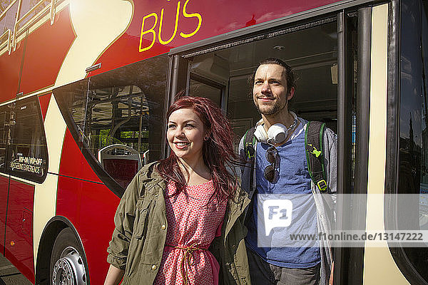 Junges erwachsenes Paar steigt aus dem Bus