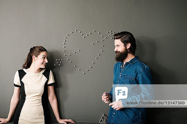 Junges Paar an der Wand mit Herzform