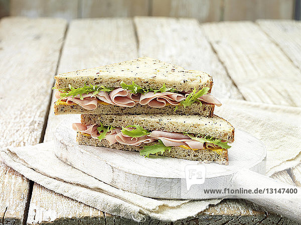Wafer thin ham  mustard and salad leaf sandwich on sliced seeded bread