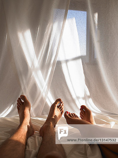 Legs of couple in bed
