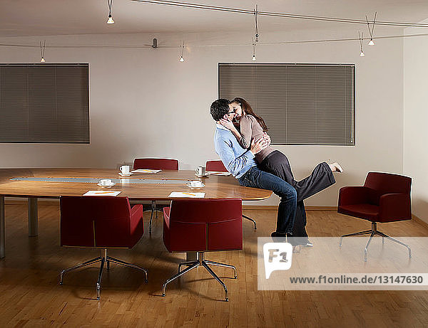 Mann und Frau küssen sich im Büro