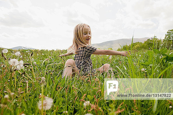 Kind spielt auf einem Feld im Frühling
