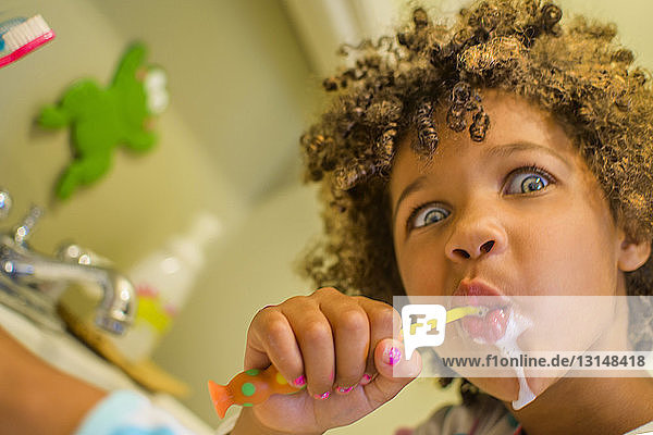 Porträt eines Mädchens  das beim Zähneputzen das Gesicht verzieht