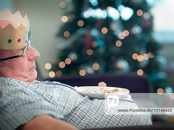 Älterer Mann mit Partyhut schlafend