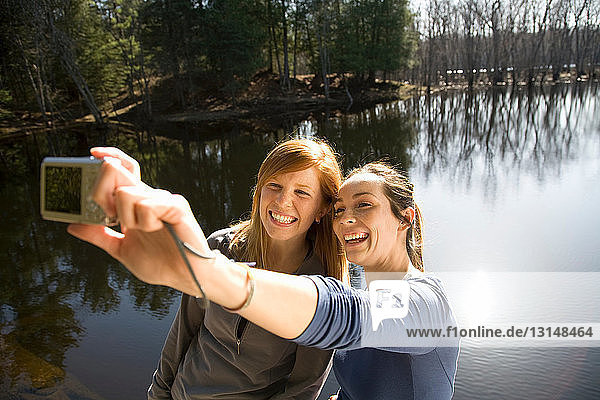 Zwei Frauen mit Kamera am Seeufer