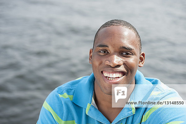 Porträt eines jungen Mannes in blauem Polohemd  lächelnd