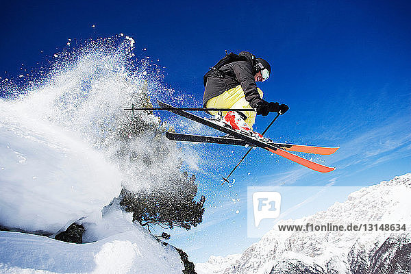 Male skier mid air on mountain