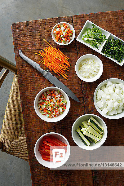 Schüsseln mit gehacktem Gemüse auf dem Tisch