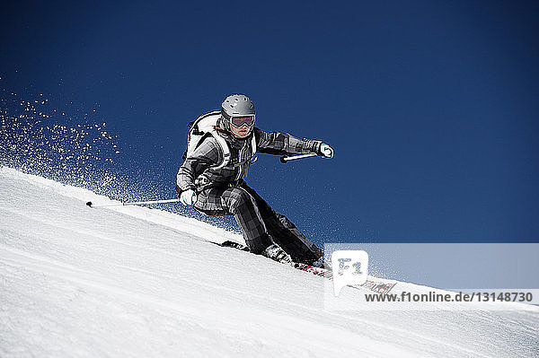Female skiing at speed down mountain