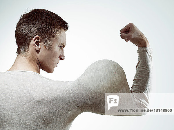 Man flexing muscles with balloon in sleeve