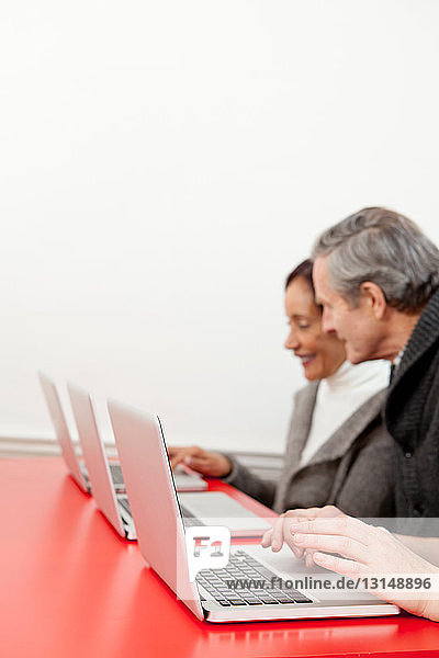 Geschäftsleute  die an Laptops arbeiten