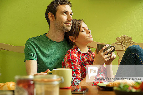 Young couple in kitchen relaxing over breakfast