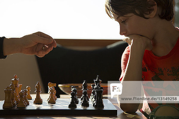Vater und Sohn spielen eine Partie Schach