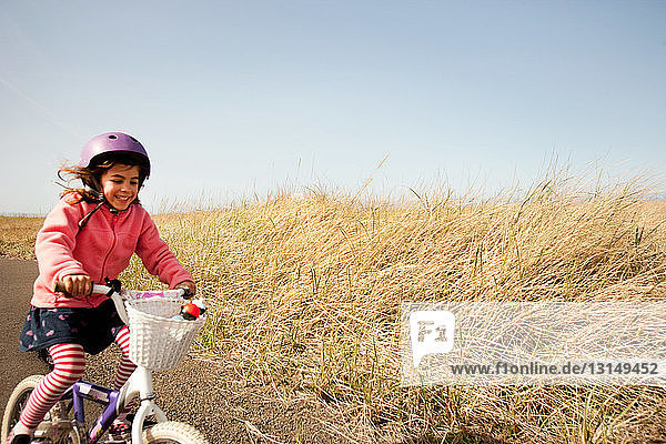 Young girl cycling along lane