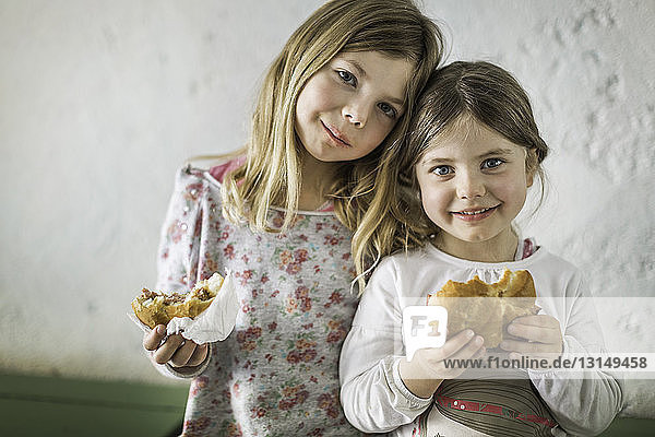 Two young girls eating savoury roll