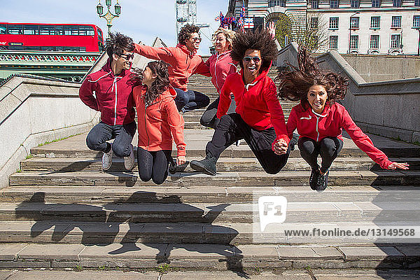Kleine Gruppe von Tänzern in der Luft über den Stufen der Stadt