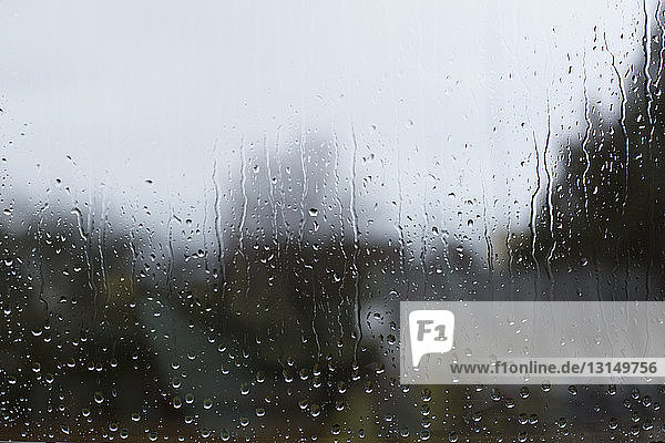 Blick durch eine Fensterscheibe mit Regentropfen
