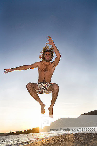 Mann springt am Strand