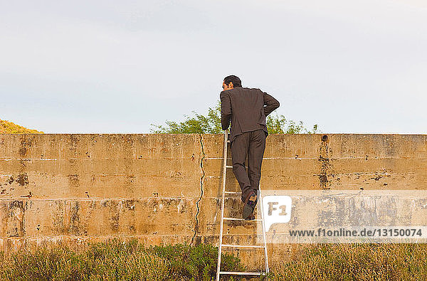 Geschäftsmann klettert über die Mauer