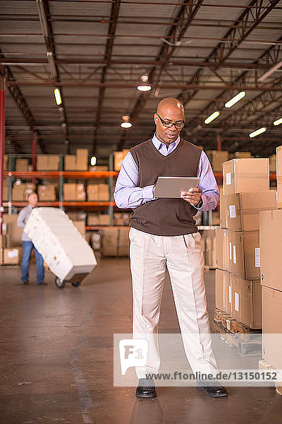 Male warehouse manager using digital tablet
