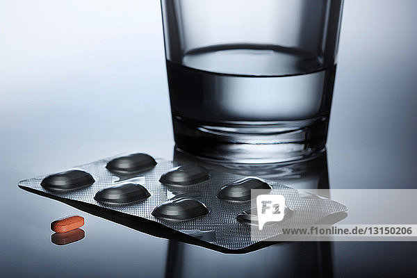 Pille mit Blisterpackung und Wasser