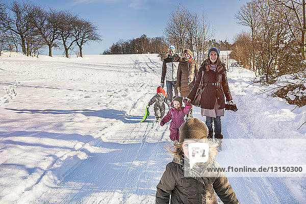 Familie beim gemeinsamen Spaziergang im Schnee