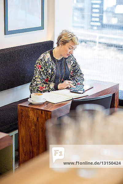 Frau benutzt digitales Tablet in einem Cafe