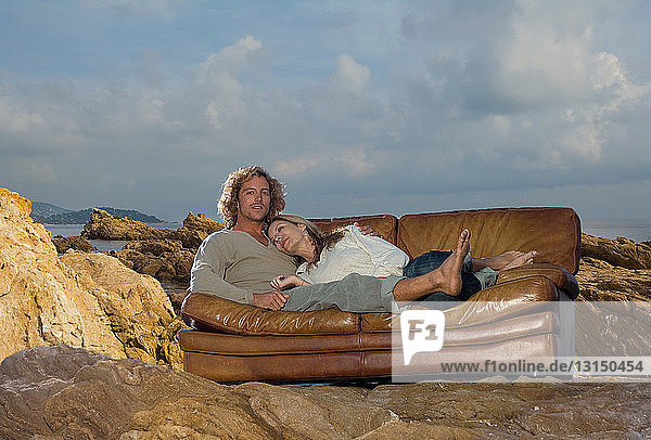 Paar entspannt sich auf der Couch am Strand