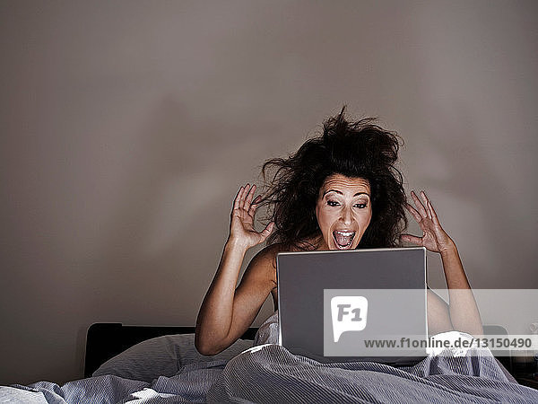 Frau im Bett am Computer